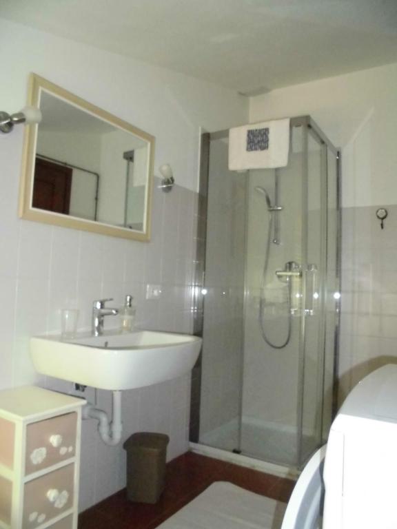 ein Bad mit einem Waschbecken und einer Dusche mit einem Spiegel in der Unterkunft VILLA COLLE in Nanto