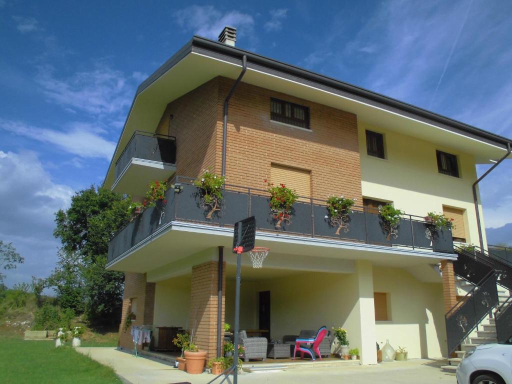ein Gebäude mit Topfpflanzen auf dem Balkon in der Unterkunft VILLA COLLE in Nanto