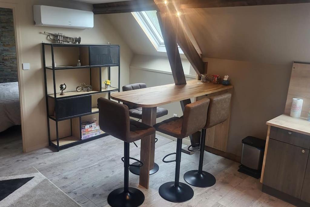 une cuisine avec une table et des chaises dans une pièce dans l'établissement Logement Cosy type Loft près de Saint Quentin, à Marcy
