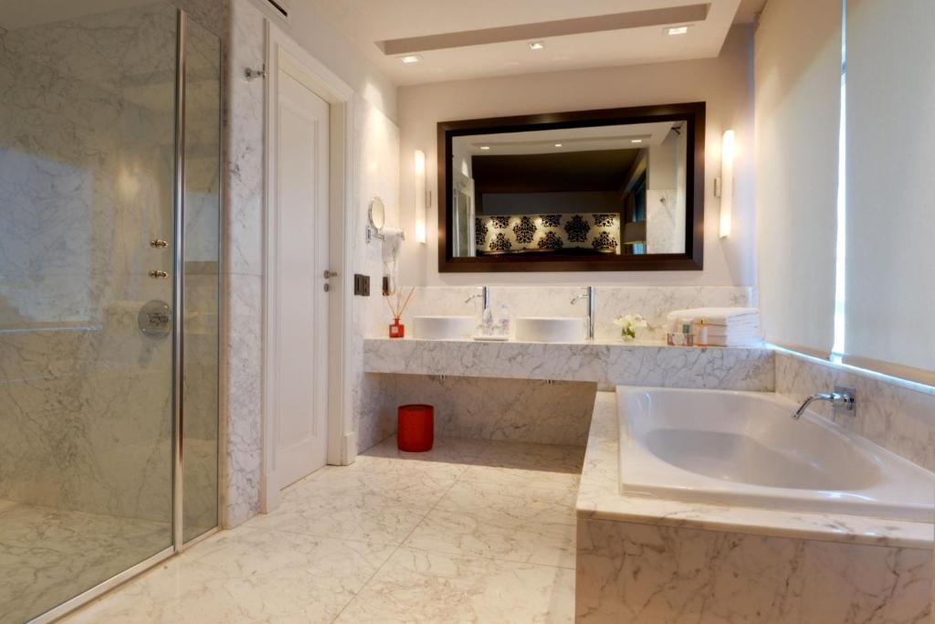a bathroom with two sinks and a tub and a mirror at Buenos Aires Marriott in Buenos Aires