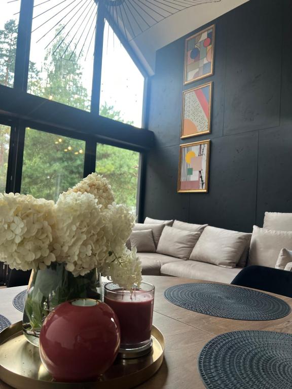 a living room with a table with a vase of flowers at Zakątek Lipowy Most in Lipowy Most