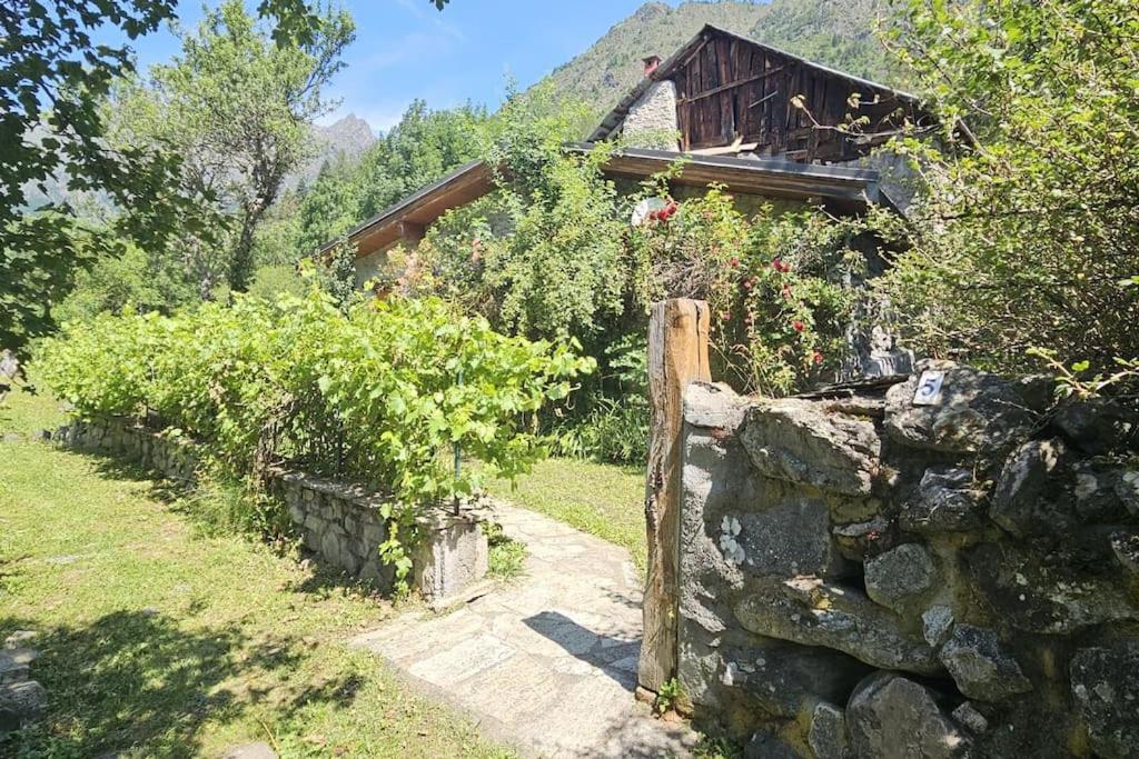 une clôture en pierre devant une maison dans l'établissement Maison cosy à la montagne, à La Chalp