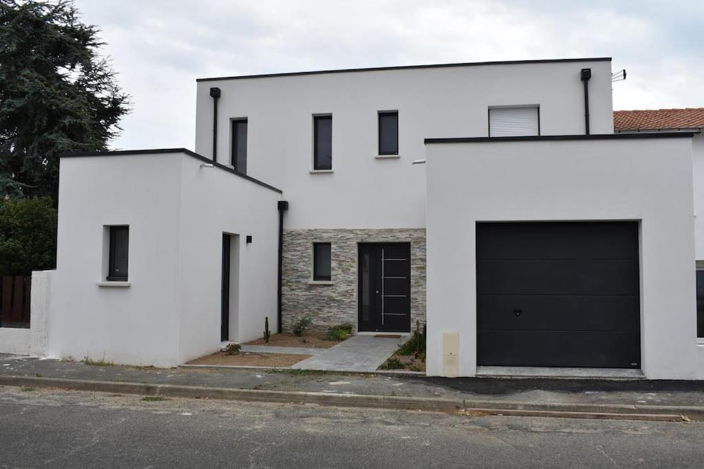 una casa blanca con dos puertas de garaje en una calle en superbe villa neuve, en Aytré