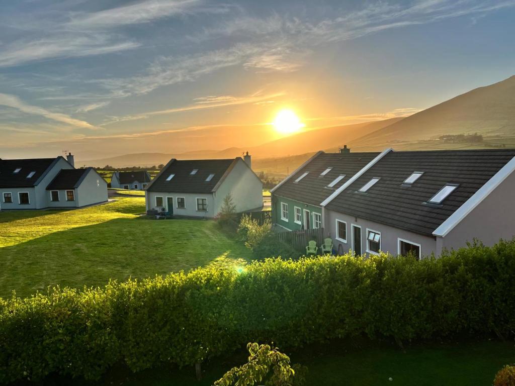 a group of houses with the sunset in the background at No's 6, 8 & 9 Dingle Lispole Holiday Homes in Lispole