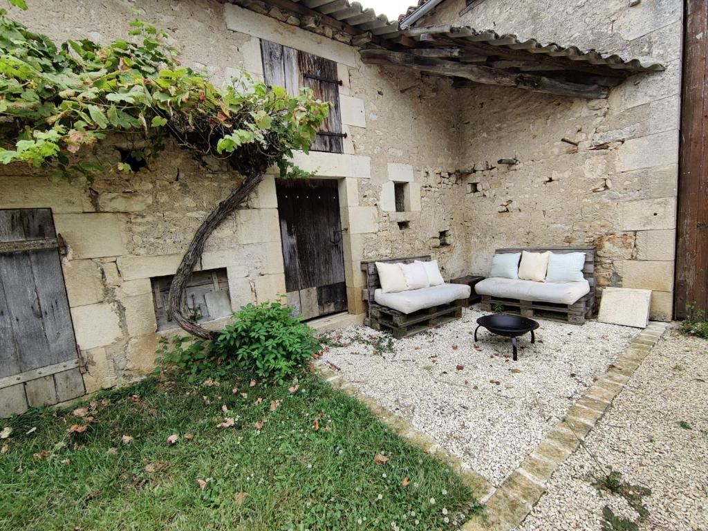 a patio with two chairs and a table in front of a building at Studio Confortable à Civaux A proximité Poitiers in Cubord