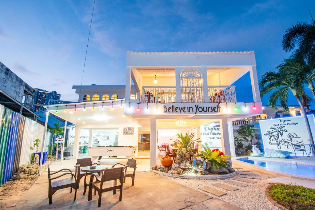 un restaurante con mesa y sillas frente a un edificio en Pupae Pool Villa Jomtien Pattaya, en Jomtien Beach