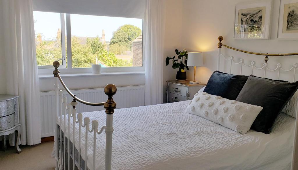 a bedroom with a white bed and a window at Lavender Cottage, a pretty period cottage in Louth in Louth