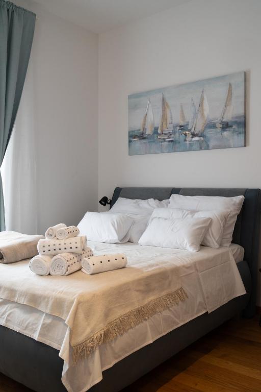 a bed with towels and a picture of sailboats at Studio Apartments Rijeka in Rijeka