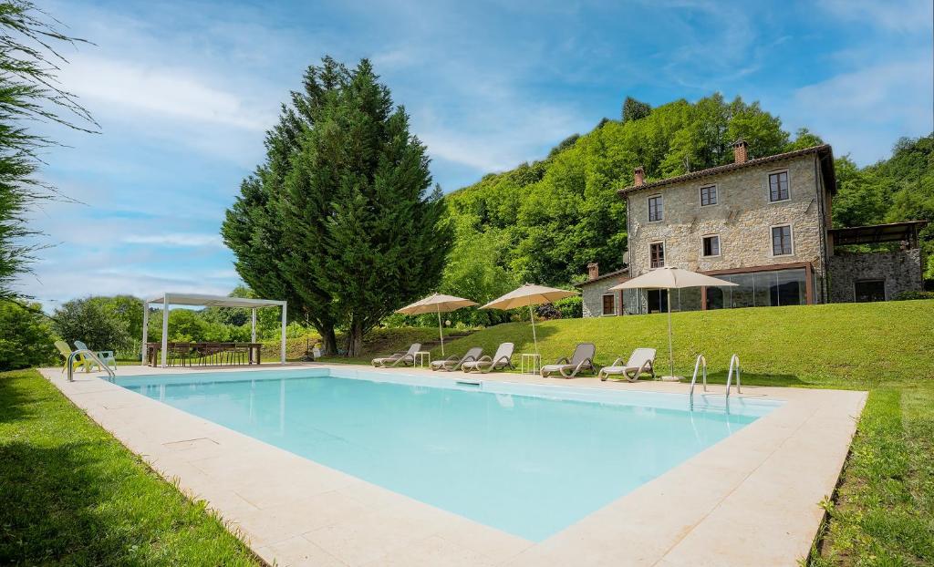 a swimming pool in front of a house at Villa Casa di Pietra en el norte de Lucca, Toscana in Camporgiano