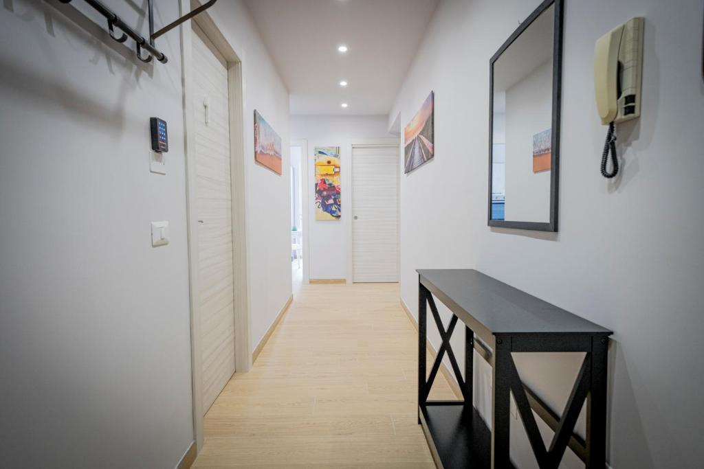un couloir avec une console noire et des murs blancs dans l'établissement Residenza NETTUNO, à Tropea