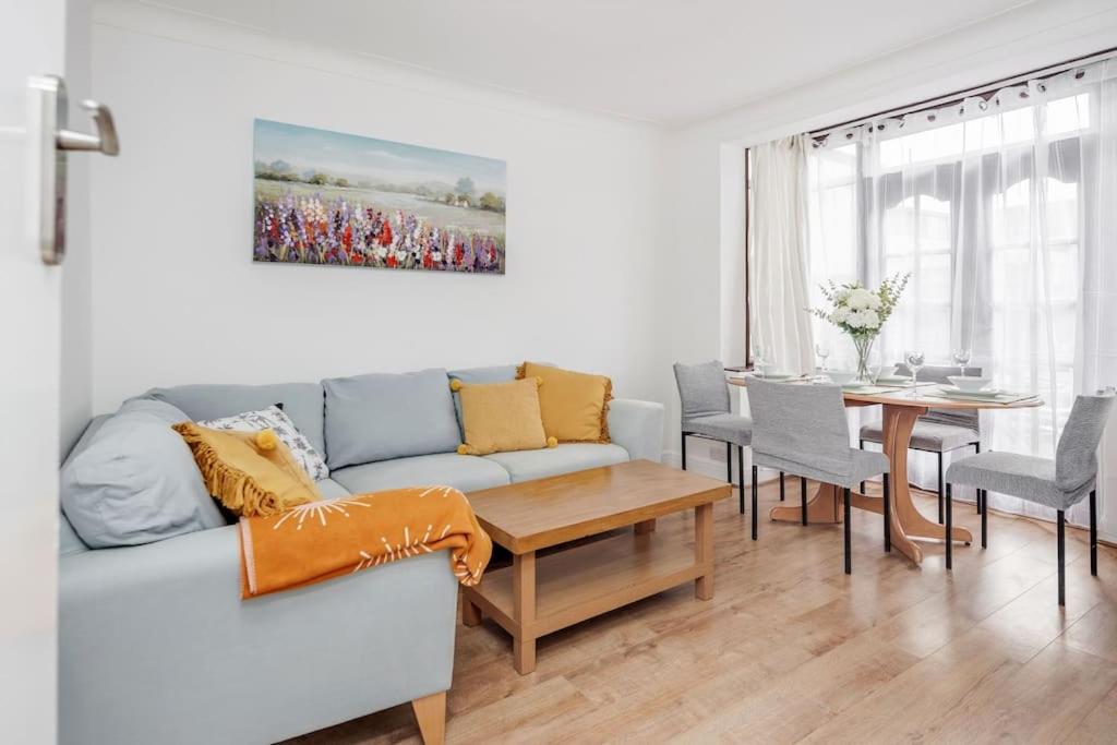 ein Wohnzimmer mit Sofa und Tisch in der Unterkunft Lovely 4 Bedrooms House Near Romford Station With Parking in Romford