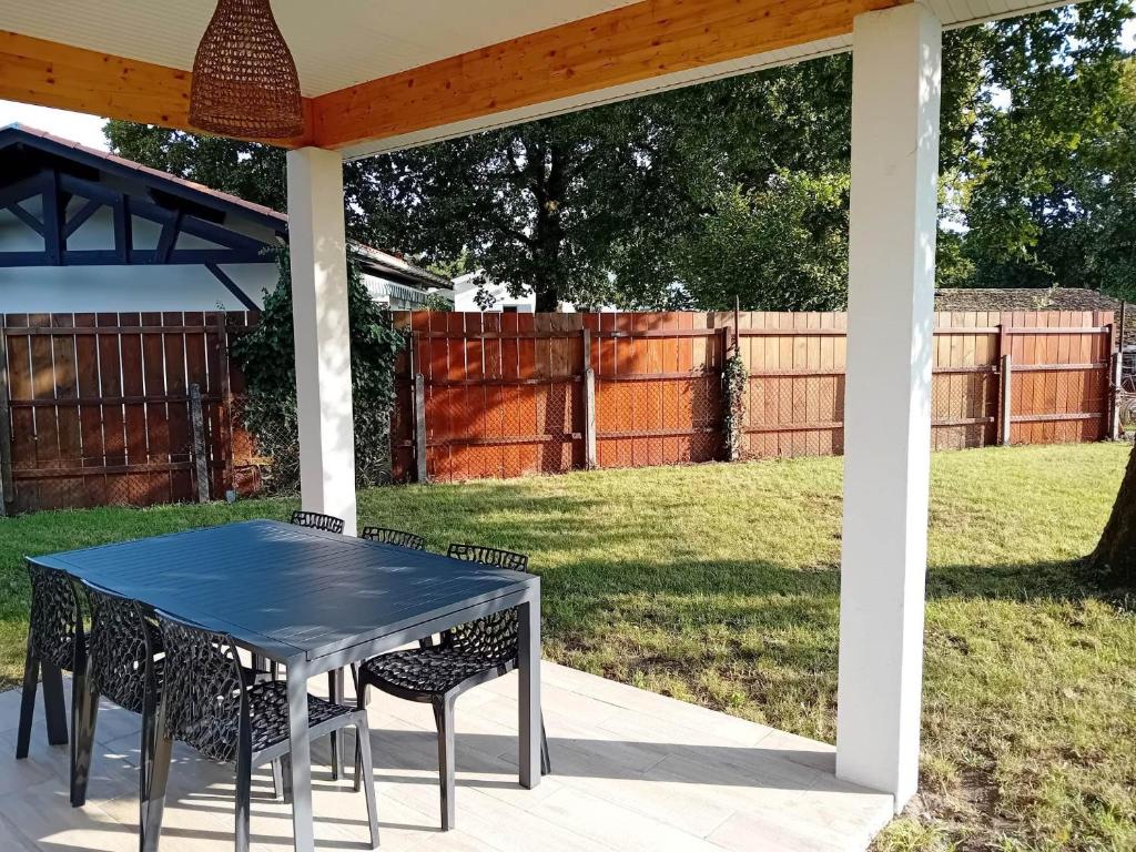 une table et deux chaises sur une terrasse dans l'établissement La Villa des Verdiers standing 6 personnes, à Andernos-les-Bains