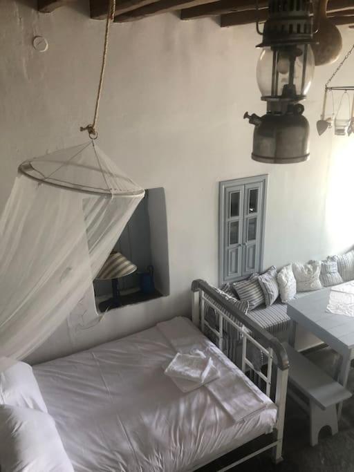 a bedroom with a bed and a table and a mirror at TaVLaDo Cycladic house in Serifos Chora