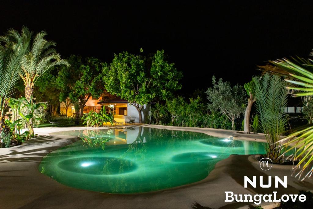 a swimming pool in a yard at night at Çıralı Nun Bungalove in Cıralı