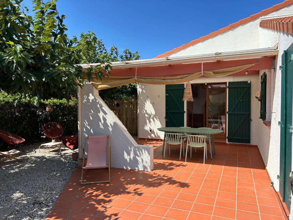 un patio d'une maison avec une table et des chaises dans l'établissement CASA Chill I Port & Plage à 500 m I Parking Privé, au Barcarès