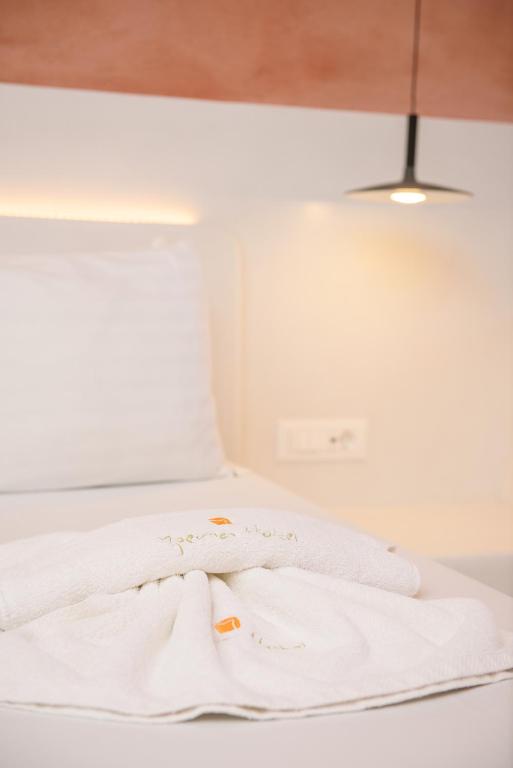a white towel sitting on top of a bed at Yperia Hotel in Aegiali