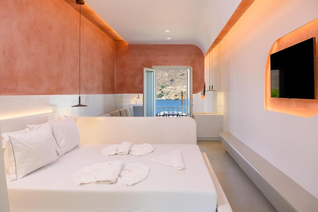 a bedroom with a white bed with two towels on it at Yperia Hotel in Aegiali