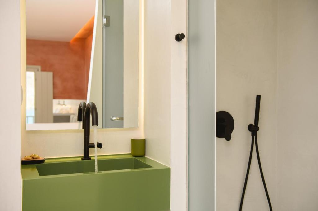 a kitchen with a sink and a mirror at Yperia Hotel in Aegiali