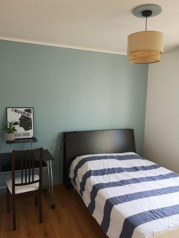 une chambre avec un lit, une table et une lampe dans l'établissement Chambre dans beau T3 très proche centre ville !, à Lorient