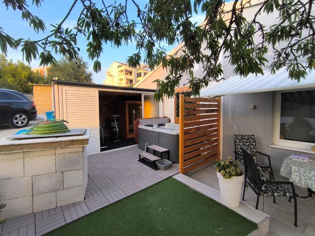 a backyard patio with a grill and a table and chairs at Wellness Apartments Ra in Primošten