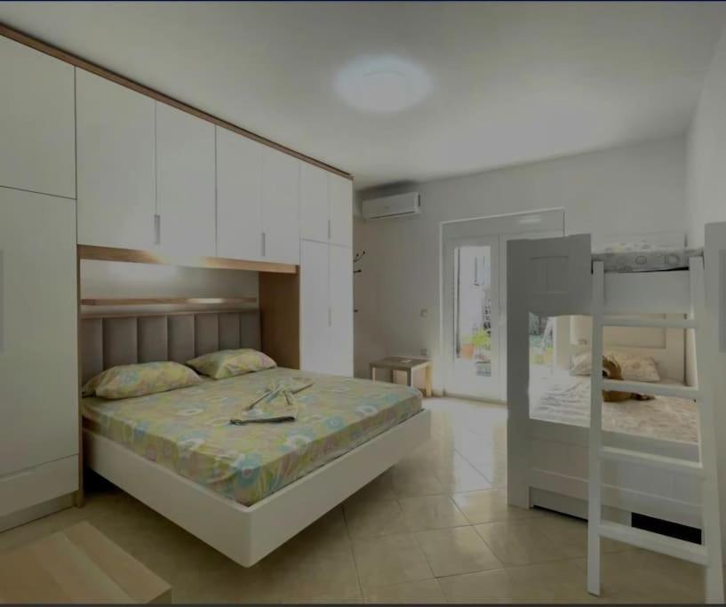 a bedroom with a large bed and white cabinets at Sunset Boulevard Holiday Home in Vlorë