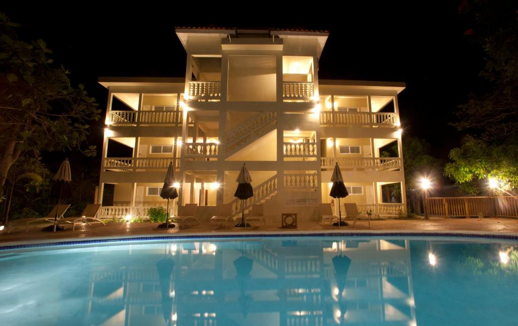 un edificio con una piscina delante de él por la noche en Sandy Haven Resort, en Negril