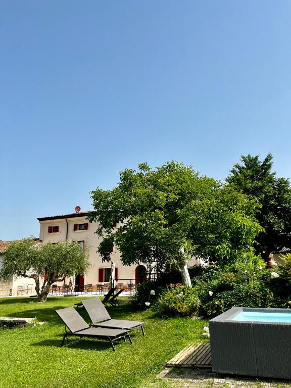 a pool and a chair in a yard with a house at Corte Massimago in Mezzane di Sotto