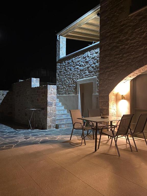 a table and chairs on a patio at night at NORI House in Moláoi