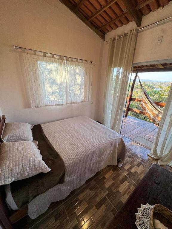 a bedroom with a bed and a large window at Pousada Bambuí Terra Ronca in São João