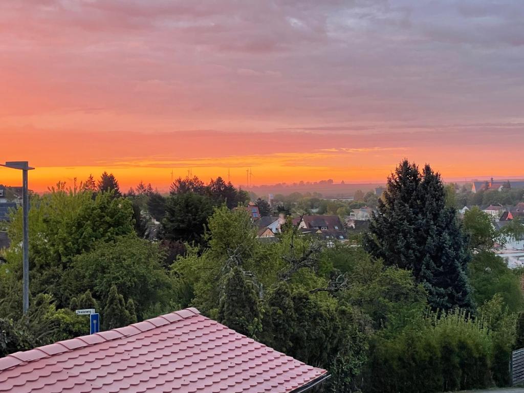 Una puesta de sol sobre una ciudad con árboles y un tejado. en Haus Valentina 1, en Bad Bergzabern