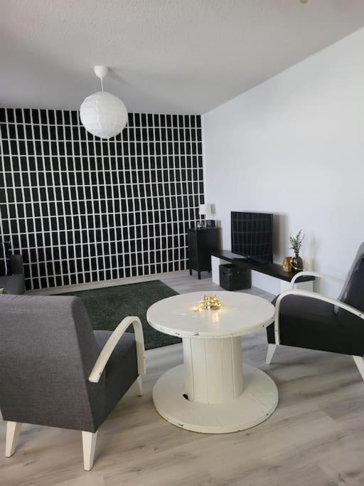 a living room with a white table and chairs at Apartmentmuikku in Siilinjärvi