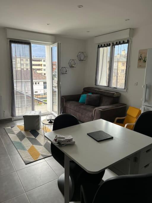 un salon avec une table et un canapé dans l'établissement Appartement cosy avec 1 place de parking privée, à Albertville