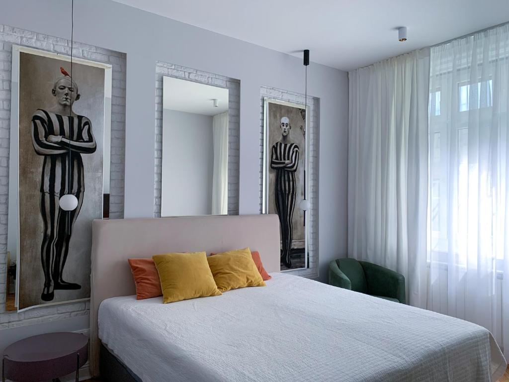a bedroom with a bed and two statues of men at Pop's Apartments in Belgrade