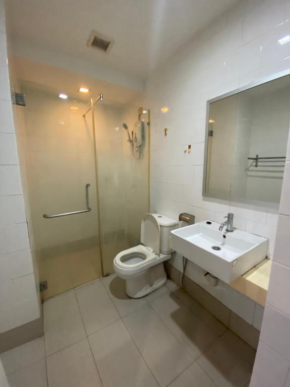 a bathroom with a toilet and a sink and a mirror at WakakaPackers in Kuala Lumpur