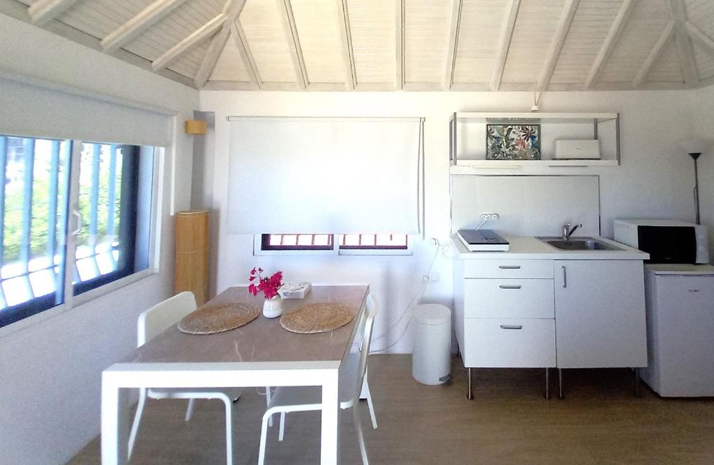 a kitchen with a table and chairs and a sink at Mandala Bungalows - Adults Only in Los Caños de Meca