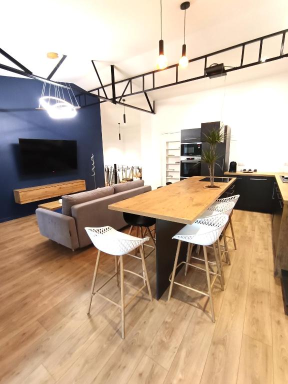 une cuisine et un salon avec une table et des chaises dans l'établissement Appartement Le Secret 140m2, Proche Sanctuaires, Climatisé, à Lourdes