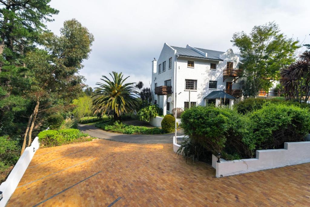 a large white house with a pathway leading to it at De Molen Guest House in Somerset West