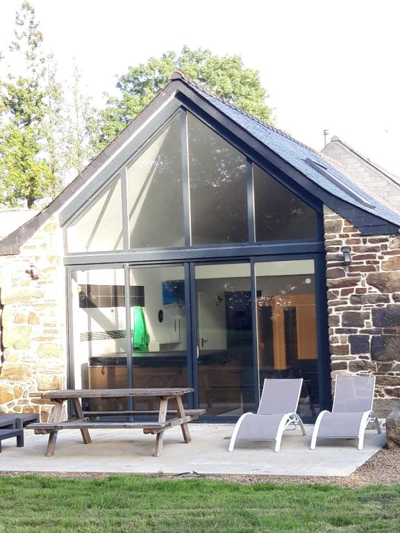 un pavillon avec une table de pique-nique et deux chaises dans l'établissement Gîte détente Domaine de Helles -Spa Privatif et Sauna, à Poullaouen