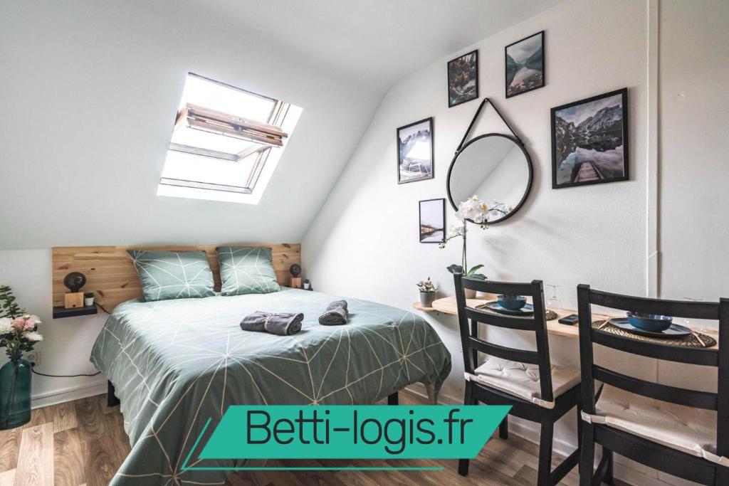 - une chambre avec un lit et un bureau avec un miroir dans l'établissement L'escale studio proche de la gare, à Reims