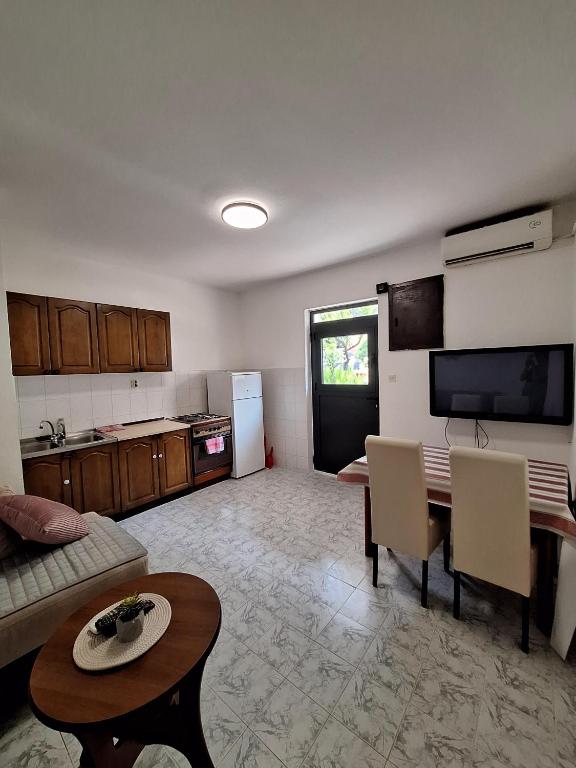 a living room with a couch and a table and a kitchen at Dobrota Comfort in Kotor