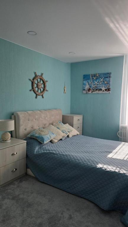 a bedroom with a bed and a clock on the wall at Kristi Apartments in Visaginas