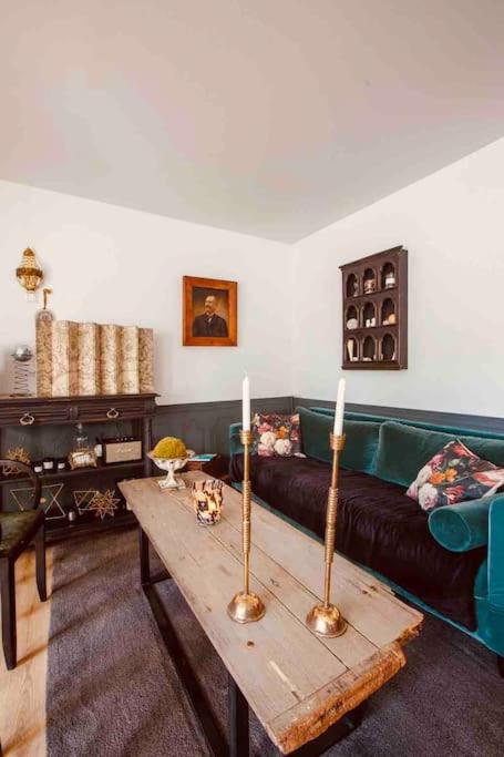 - un salon avec un canapé et une table avec deux bougies dans l'établissement Maison Etadame, à Aizier