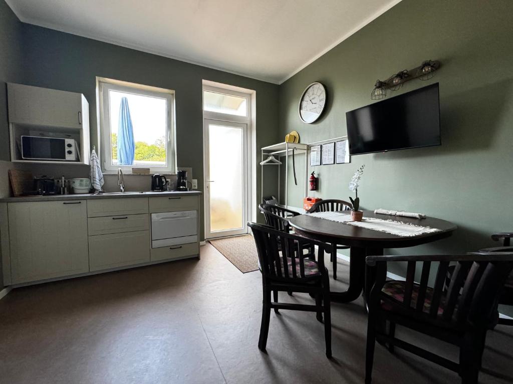 a kitchen and dining room with a table and chairs at Comfort Apartment - mit 4 Betten in Raubach