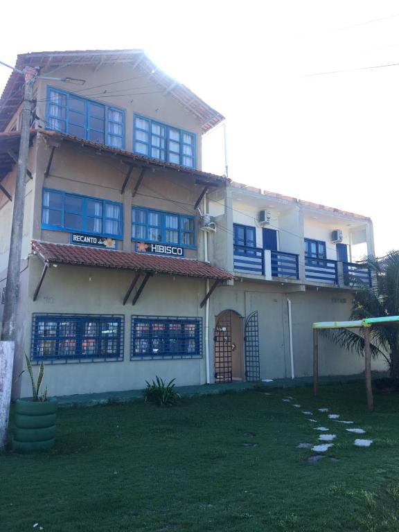 a large house with blue windows and a yard at Recanto do Hibisco in Prado