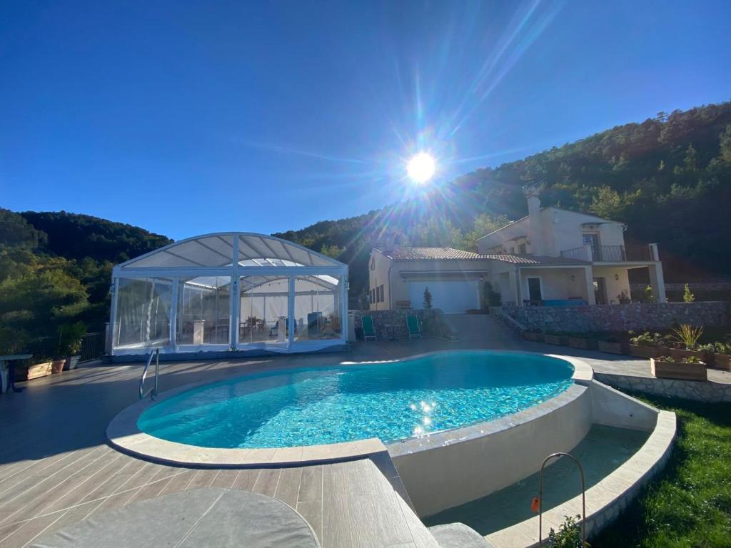 a villa with a swimming pool in front of a house at Villa Safran in Peille
