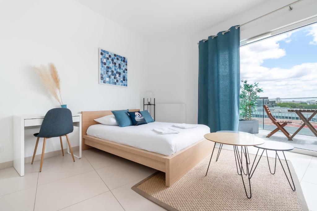 une chambre avec un lit, une table et une fenêtre dans l'établissement L'ensoleillé Superbe studio avec garage, à Caen