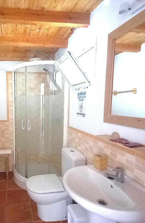 a bathroom with a shower and a toilet and a sink at Mandala Bungalows - Adults Only in Los Caños de Meca