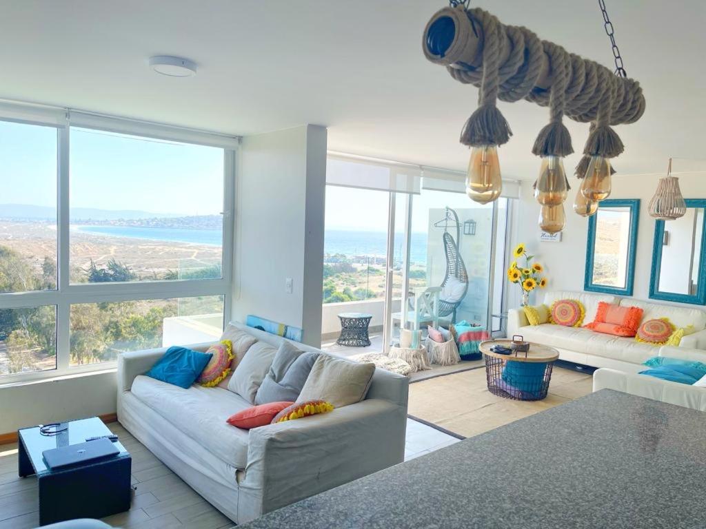 トンゴイにあるLa mejor vista en Puerto Veleroのソファと大きな窓のあるリビングルーム