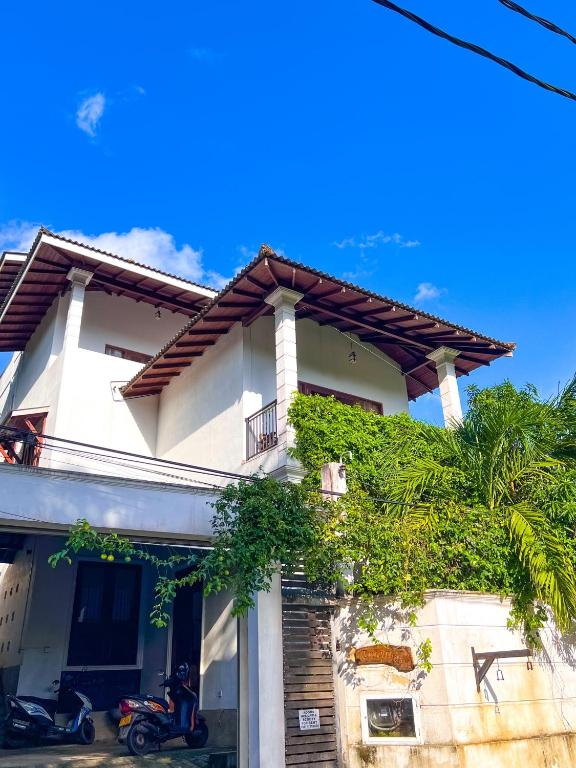 a house with a motorcycle parked in front of it at Heaven Hill Guesthouse in Weligama