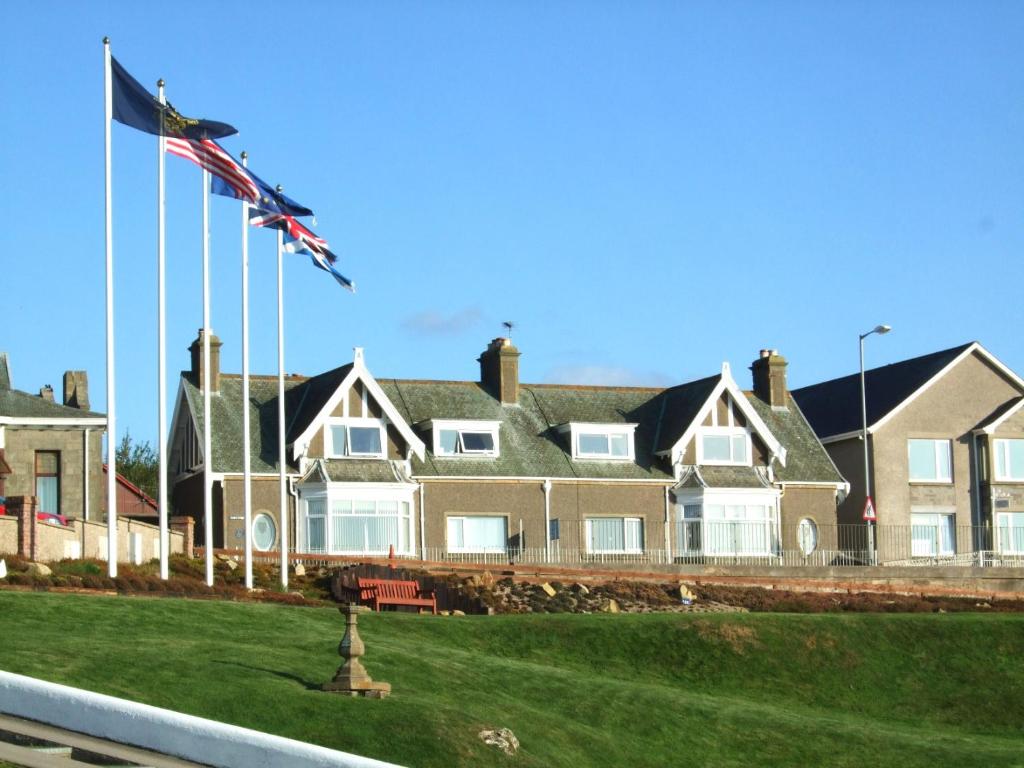 una casa grande con una bandera delante de ella en Links Lodge, en Lossiemouth